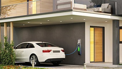 Ein modernes Haus mit einer Photovoltaikanlage und einem Elektroauto das geladen wird